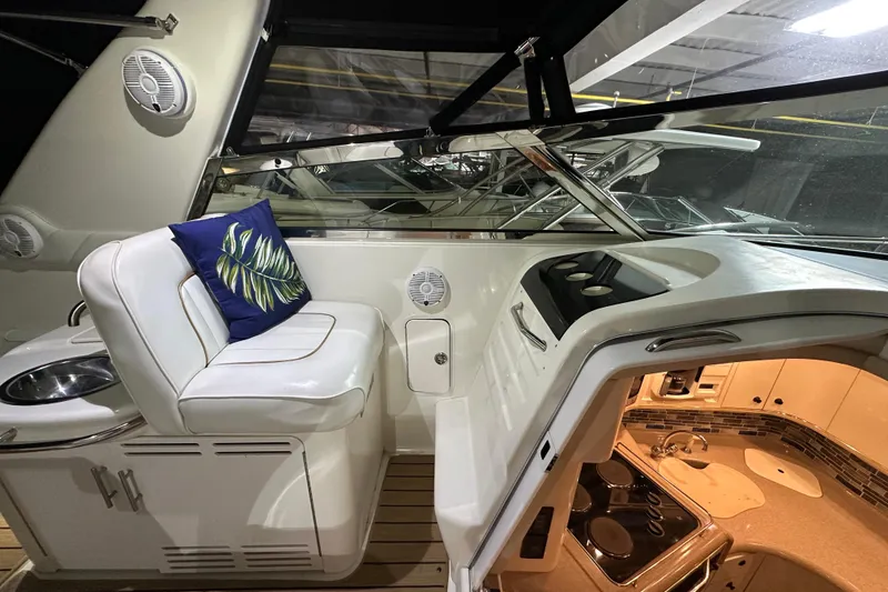 Slide: The Image of 1997 Sea Ray Sundancer 370 interior with white seating, blue cushion, and kitchenette. - 17