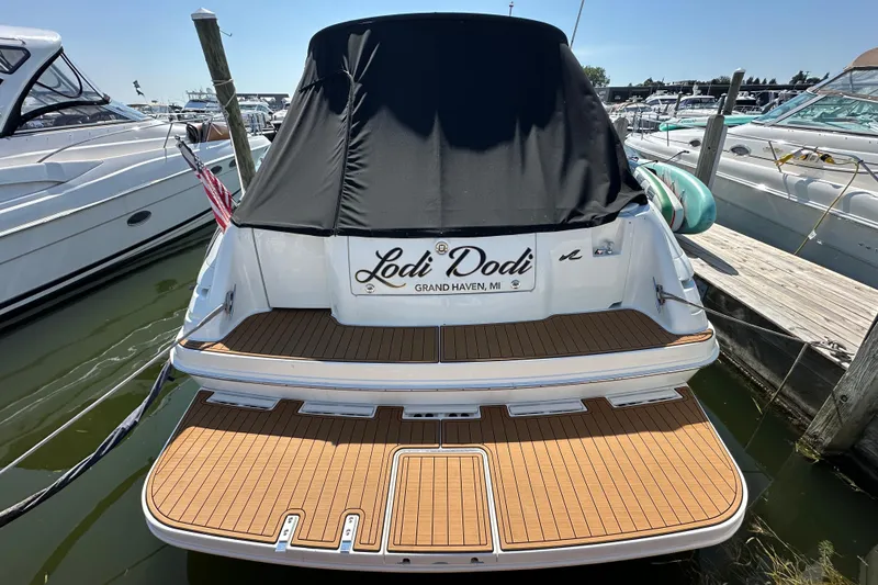 Slide: The Image of 1997 Sea Ray Sundancer 370 docked, rear view with black cover and wooden deck. - 2