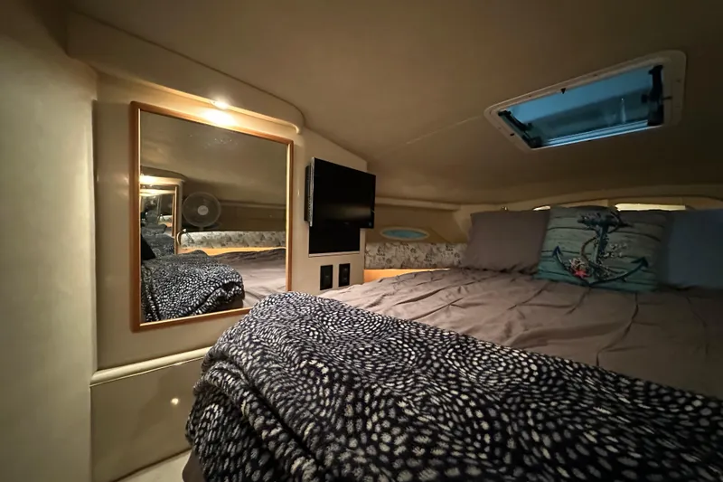 Slide: The Image of Cozy cabin interior of 1997 Sea Ray Sundancer 370 with bed, mirror, and TV. - 23