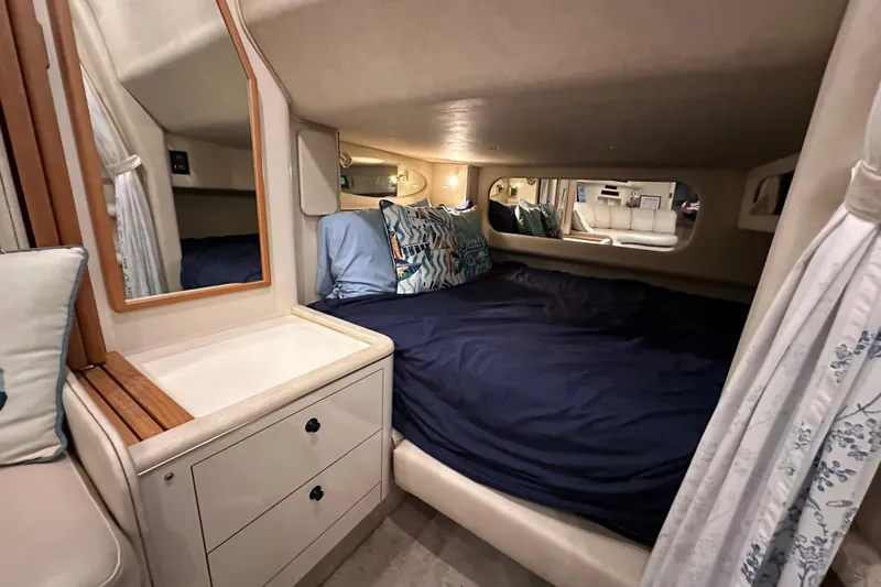 Slide: The Image of Cozy cabin interior of 1997 Sea Ray Sundancer 370 with bed, mirror, and storage. - 25