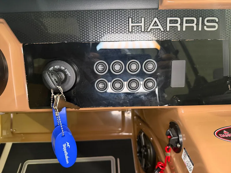 Slide: The Image of The image shows the dashboard of a Harris Solstice 250 boat with switches and an ignition key. - 40