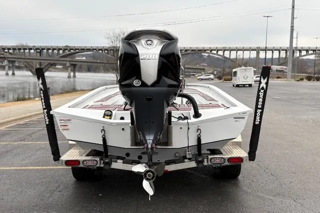 Slide: The Image of 2024 Express H22B boat with powerful engine, parked near a scenic bridge. - 11