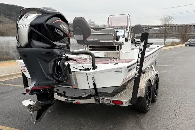 Slide: The Image of 2024 Express H22B boat with Yamaha engine on a trailer by a river. - 13