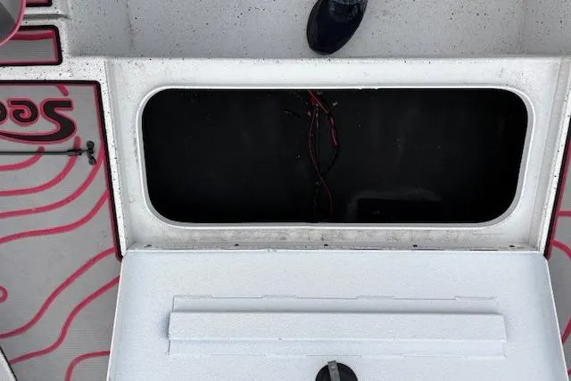 Slide: The Image of 2024 Express H22B boat storage compartment with open lid and visible wiring. - 27