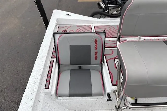 Slide: The Image of 2024 Express H22B boat interior with gray and pink seating, featuring "Xpress Boats" branding. - 33