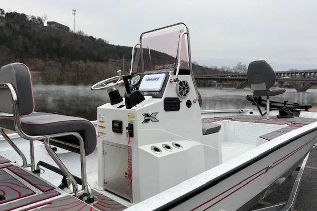 Slide: The Image of 2024 Express H22B boat with console and seating, docked by a scenic river. - 60
