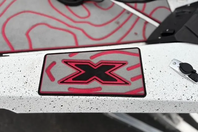 Slide: The Image of 2024 Express H22B boat with red and black "X" logo on speckled surface. - 66