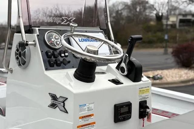 Slide: The Image of 2024 Express H22B boat console with steering wheel and controls, featuring Lowrance electronics. - 68