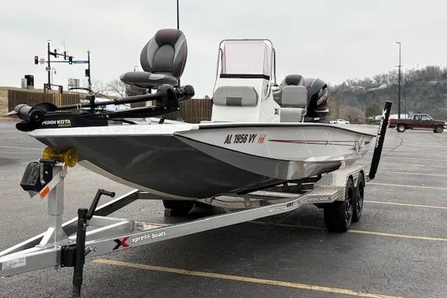 Slide: The Image of 2024 Express H22B boat on trailer in parking lot, featuring Minn Kota trolling motor. - 9