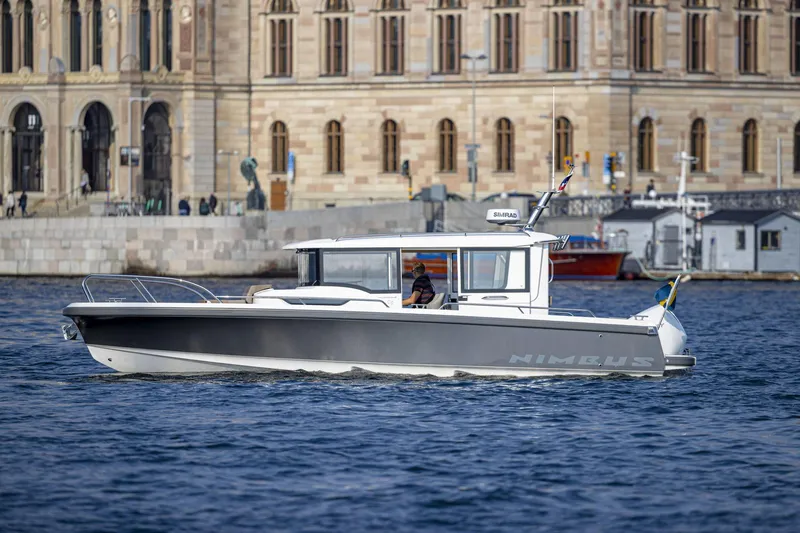 The Image of 2025 Nimbus Commuter 9 boat cruising near historic waterfront buildings. - 0
