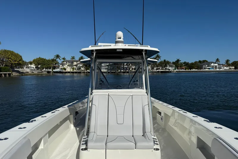 Slide: The Image of 2018 SeaVee 390Z boat on calm water, showcasing sleek design and spacious deck. - 14