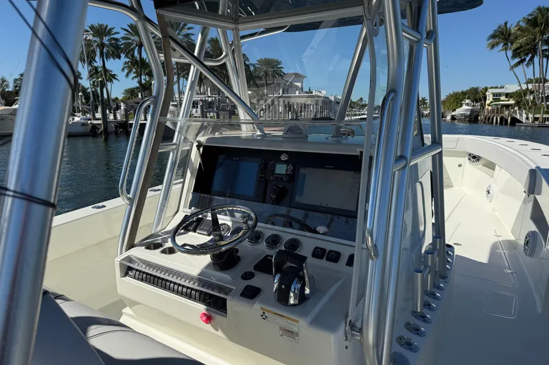 Slide: The Image of 2018 SeaVee 390Z boat cockpit with steering wheel and navigation controls, dockside view. - 19