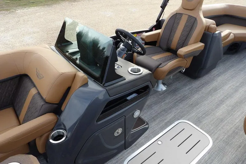 Slide: The Image of 2026 Bennington 22 MFB boat interior with luxurious brown seating and modern dashboard. - 16