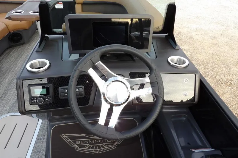 Slide: The Image of 2026 Bennington 22 MFB boat dashboard with steering wheel, cup holders, and control panel. - 28