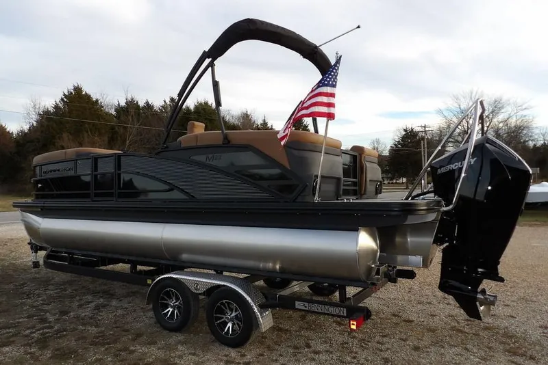 Slide: The Image of 2026 Bennington 22 MFB pontoon boat on trailer with American flag and Mercury engine. - 3