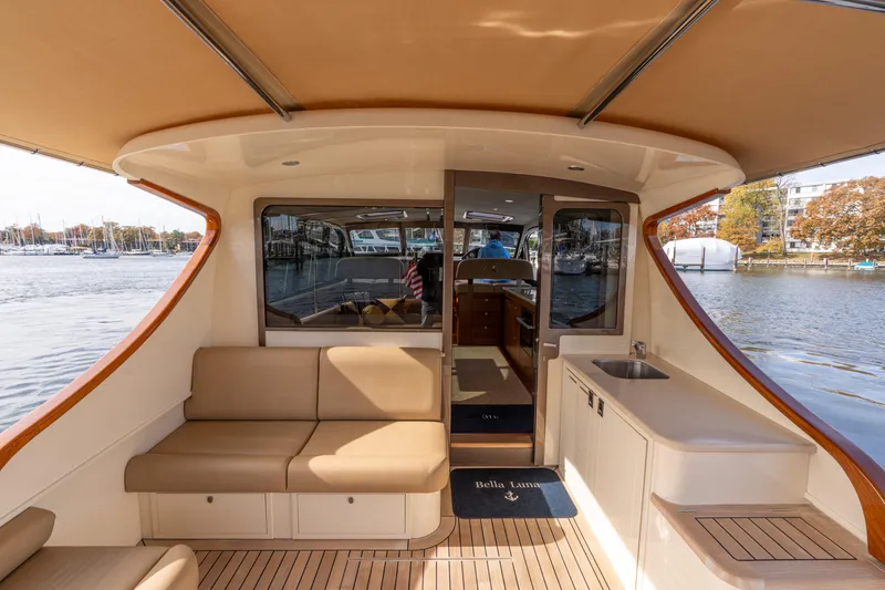 Slide: The Image of 2016 Palm Beach Motor Yachts PB50 interior with seating, sink, and water view. - 4