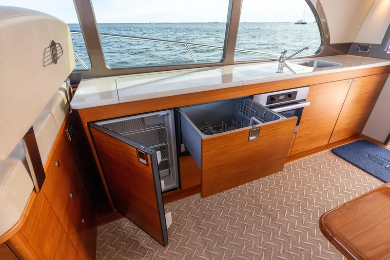 Slide: The Image of Interior of 2016 Palm Beach Motor Yachts PB50, featuring a modern kitchen with ocean view. - 49