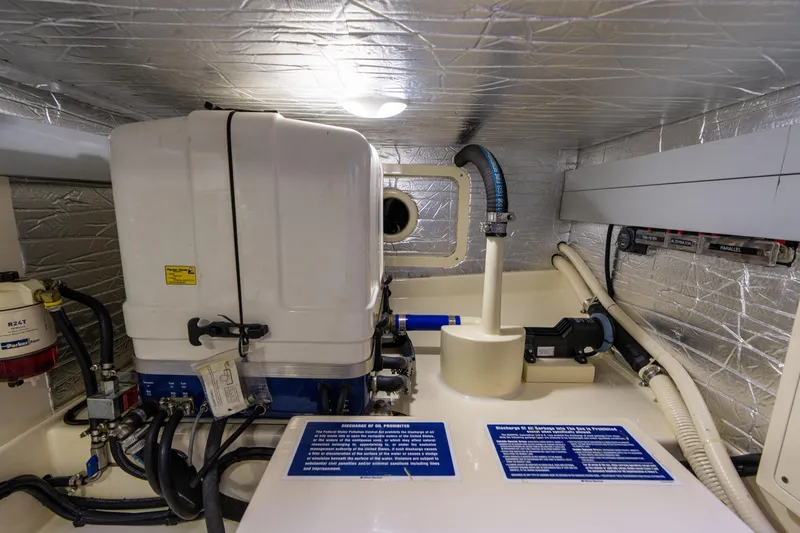 Slide: The Image of Engine room of 2016 Palm Beach Motor Yachts PB50, featuring mechanical components and safety labels. - 51