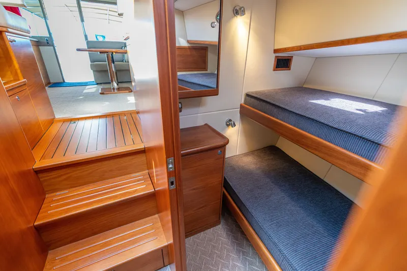 Slide: The Image of 2016 Palm Beach Motor Yachts PB50 interior with wooden stairs and cozy bunk beds. - 63