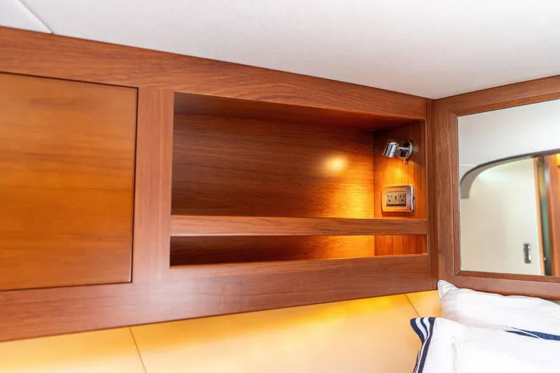 Slide: The Image of Luxurious wooden interior of 2016 Palm Beach Motor Yachts PB50 cabin with lighting and power outlet. - 66