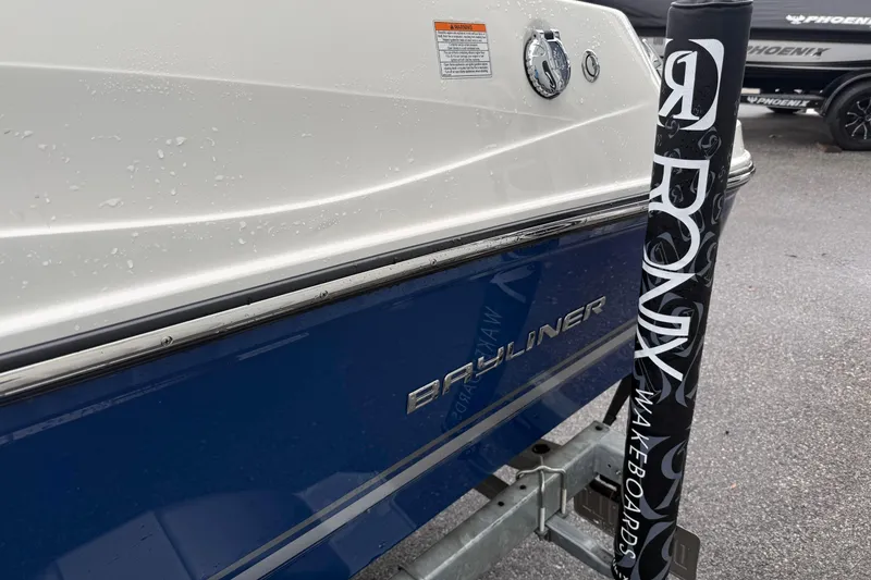 Slide: The Image of 2022 Bayliner 170 Bowrider boat with blue and white exterior on a trailer. - 12