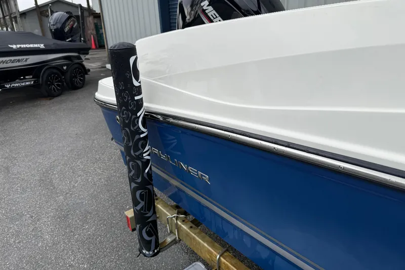 Slide: The Image of 2022 Bayliner 170 Bowrider boat, blue and white exterior, parked on a trailer. - 13