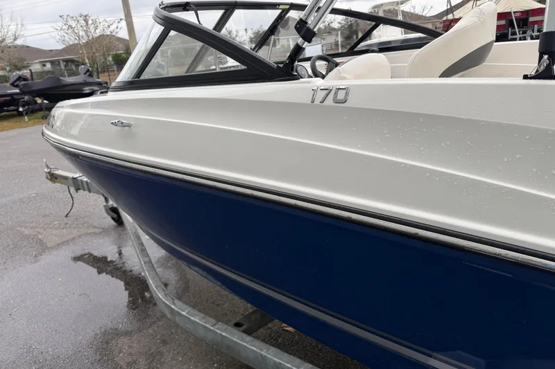 Slide: The Image of 2022 Bayliner 170 Bowrider boat on trailer, showcasing sleek design and blue hull. - 5