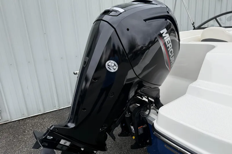 Slide: The Image of 2022 Bayliner 170 Bowrider with Mercury outboard motor, parked near a white wall. - 6