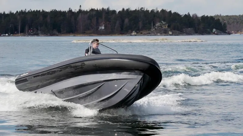 Slide: The Image of 2024 Northstar Orion 6 boat cruising on a lake with forested shoreline. - 2