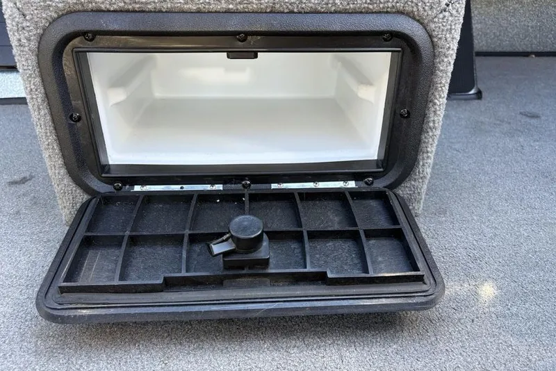 Slide: The Image of Open storage compartment in a 2019 Nitro ZV19 boat, featuring a black latch. - 18