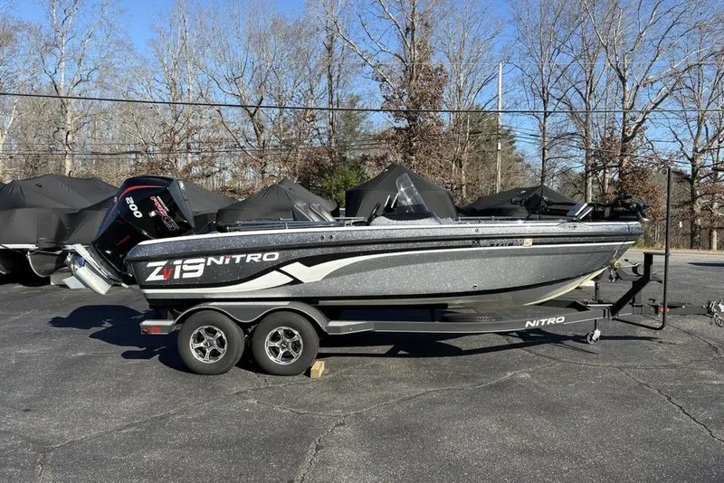 Slide: The Image of 2019 Nitro ZV19 boat on trailer, parked outdoors, with trees in the background. - 3