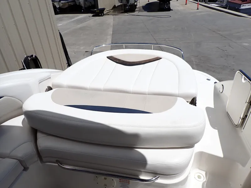 Slide: The Image of 2011 Chaparral 287 SSX boat with white cushioned seating in a marina setting. - 10