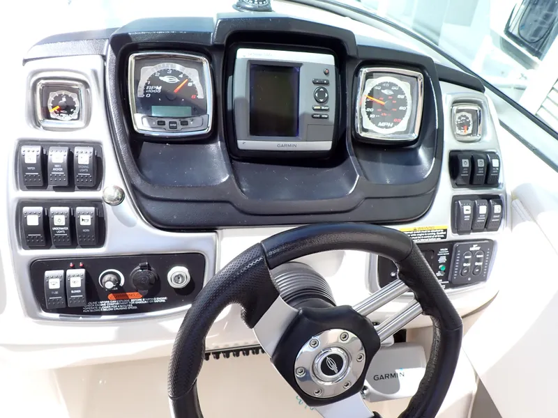 Slide: The Image of Dashboard of 2011 Chaparral 287 SSX boat with steering wheel and control gauges. - 12