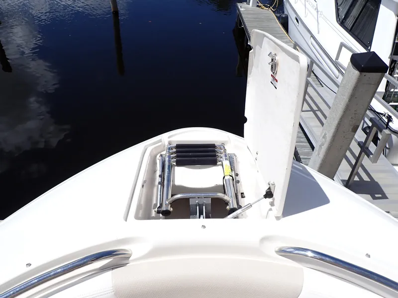 Slide: The Image of 2011 Chaparral 287 SSX boat with open bow storage and ladder, docked by the water. - 18