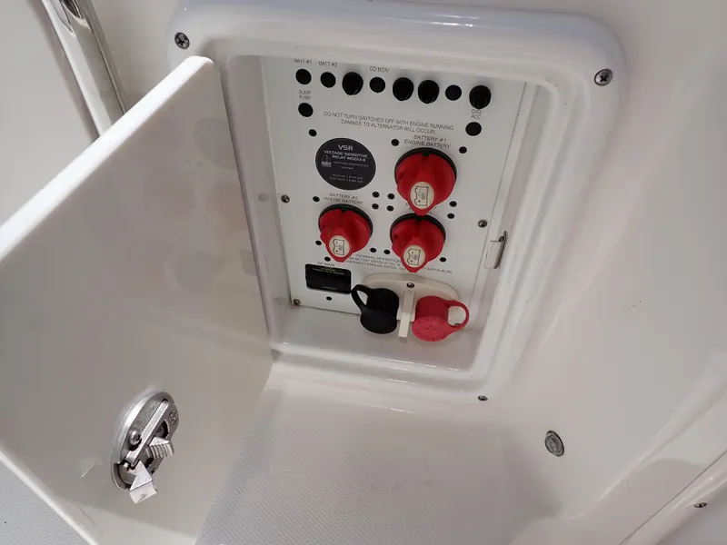Slide: The Image of Electrical panel on 2011 Chaparral 287 SSX boat with red switches and white casing. - 27