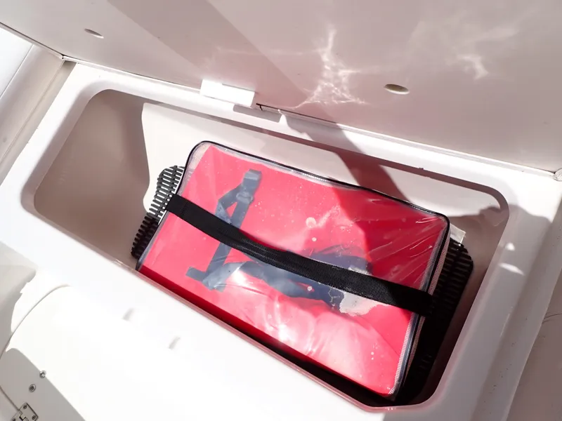 Slide: The Image of Storage compartment in a 2011 Chaparral 287 SSX boat with a red bag inside. - 34