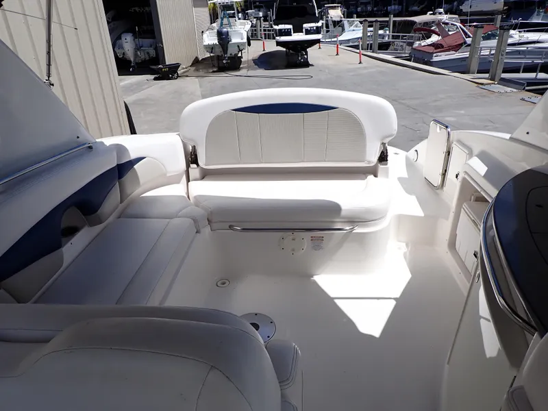 Slide: The Image of 2011 Chaparral 287 SSX boat interior with white seating and dockside view. - 6