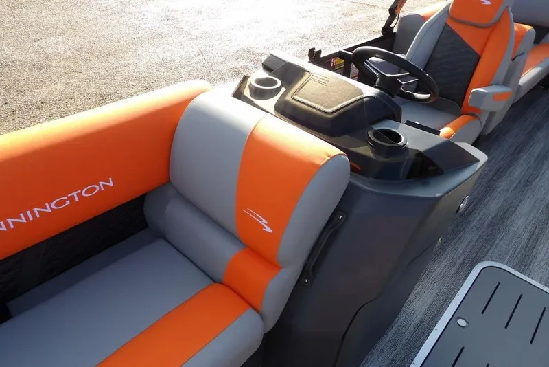 Slide: The Image of 2026 Bennington 22 SSR boat interior with orange and gray seating, steering console, and cup holders. - 17