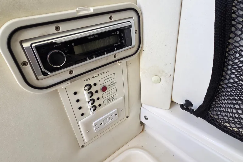 Slide: The Image of 2006 Century 2900 Center Console boat control panel with Kenwood stereo and AC outlets. - 10
