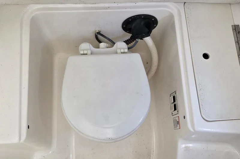 Slide: The Image of Boat toilet in a 2006 Century 2900 Center Console, featuring a white seat and plumbing. - 12