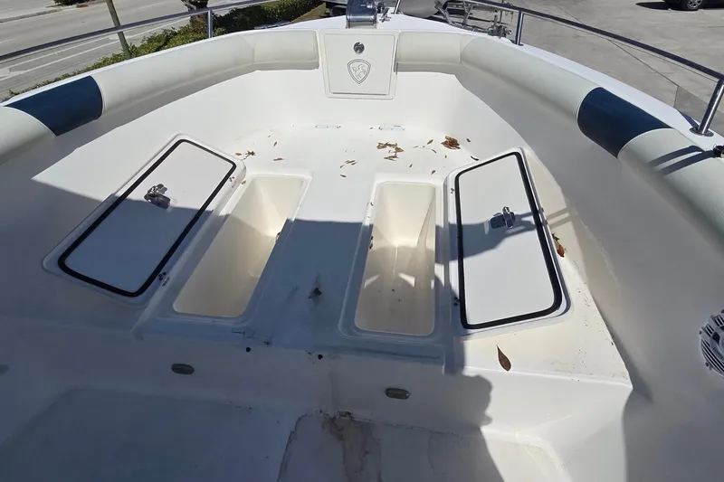 Slide: The Image of 2006 Century 2900 Center Console boat with open storage compartments and scattered leaves. - 14