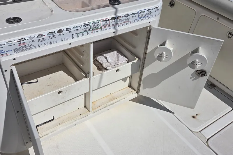 Slide: The Image of Open storage compartment on a 2006 Century 2900 Center Console boat with fishing ruler. - 9