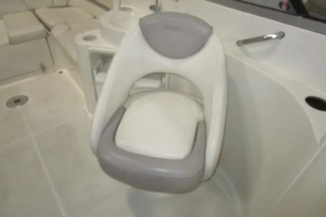 Slide: The Image of 2004 Stingray 240 LR boat interior with swivel seat and white upholstery. - 11