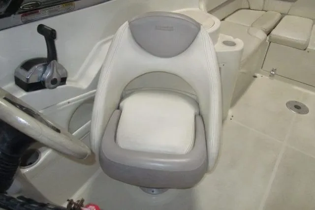 Slide: The Image of 2004 Stingray 240 LR boat interior with steering wheel and cushioned seat. - 12