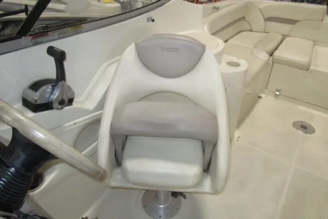 Slide: The Image of 2004 Stingray 240 LR boat interior with steering wheel and seating area. - 14