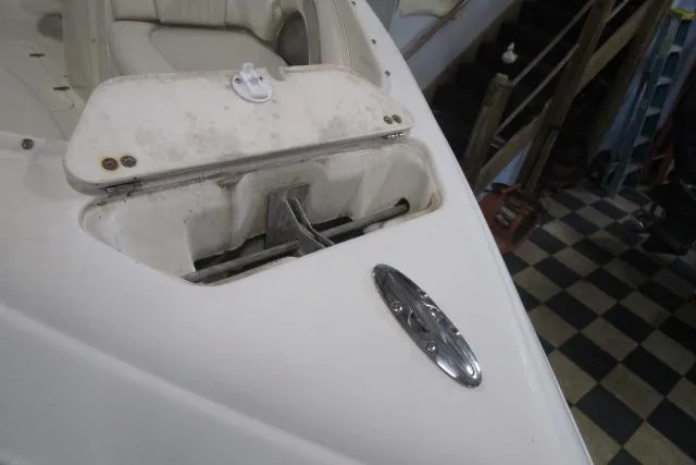 Slide: The Image of 2004 Stingray 240 LR boat anchor compartment with checkered floor background. - 21