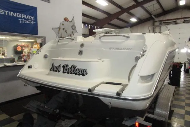 Slide: The Image of 2004 Stingray 240 LR boat in showroom, rear view with "Just Believe" text. - 22