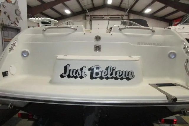Slide: The Image of 2004 Stingray 240 LR boat with "Just Believe" text on the stern in a warehouse. - 4