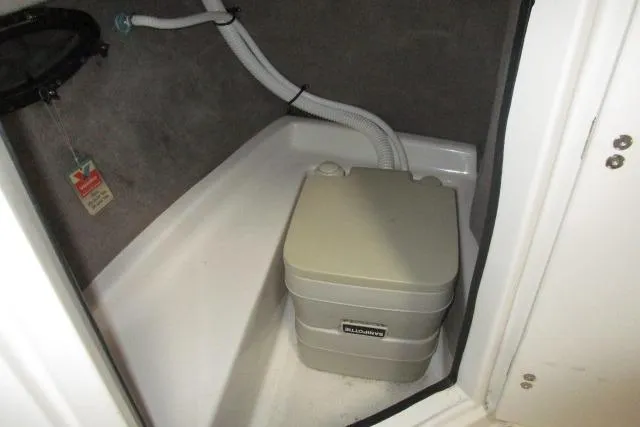 Slide: The Image of Portable toilet in 2004 Stingray 240 LR boat compartment with plumbing hoses. - 7