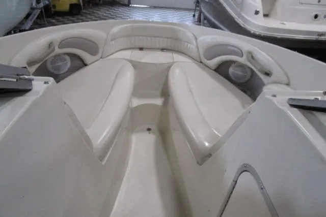 Slide: The Image of 2004 Stingray 240 LR boat interior with white cushioned seating and built-in speakers. - 8